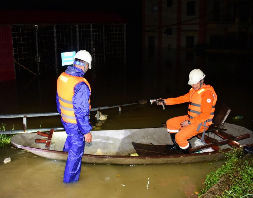 Công nhân Công ty Điện lực huyện Sóc Sơn kiểm tra an toàn để cấp điện trở lại cho các hộ dân thôn Lương Phúc ở ngoài đê Hữu Cầu, thuộc xã Việt Long, huyện Sóc Sơn từ 21h ngày 12/9. (Ảnh: TTXVN phát)