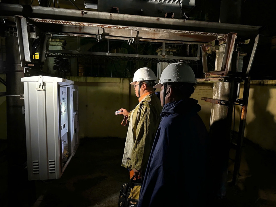 Công nhân Công ty Điện lực huyện Sóc Sơn kiểm tra an toàn để cấp điện trở lại cho các hộ dân thôn Lương Phúc ở ngoài đê Hữu Cầu, thuộc xã Việt Long, huyện Sóc Sơn từ 21h ngày 12/9. (Ảnh: TTXVN phát)