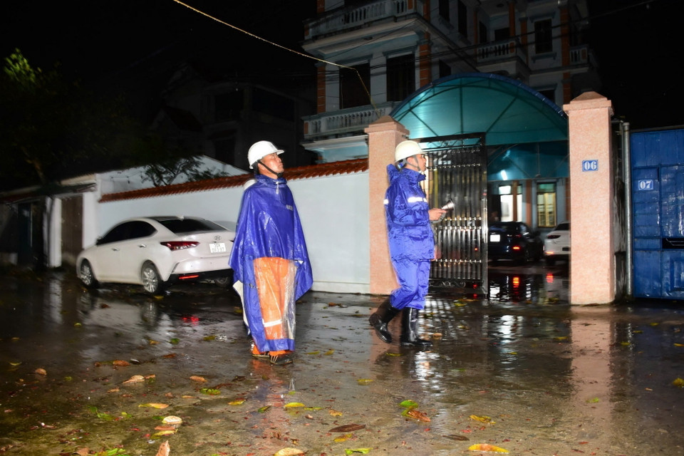 Công nhân Công ty Điện lực huyện Sóc Sơn kiểm tra an toàn để cấp điện trở lại cho các hộ dân thôn Lương Phúc ở ngoài đê Hữu Cầu, thuộc xã Việt Long, huyện Sóc Sơn từ 21h ngày 12/9. (Ảnh: TTXVN phát)