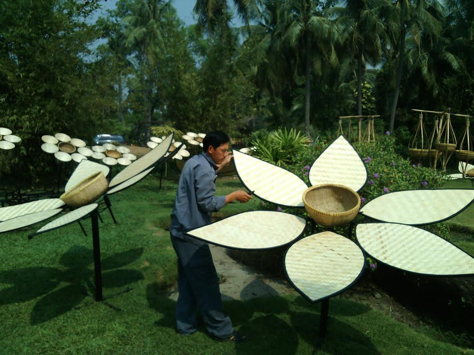 Các nghệ nhân đang chỉnh sửa tác phẩm hoàn thiện. (Ảnh: Gia Thuận/Vietnam+)