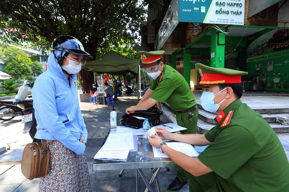 Một trường hợp ra đường không có lý do bị lập biên bản tại chốt kiểm dịch phường Thanh Xuân Bắc. (Ảnh: Tuấn Anh/TTXVN)
