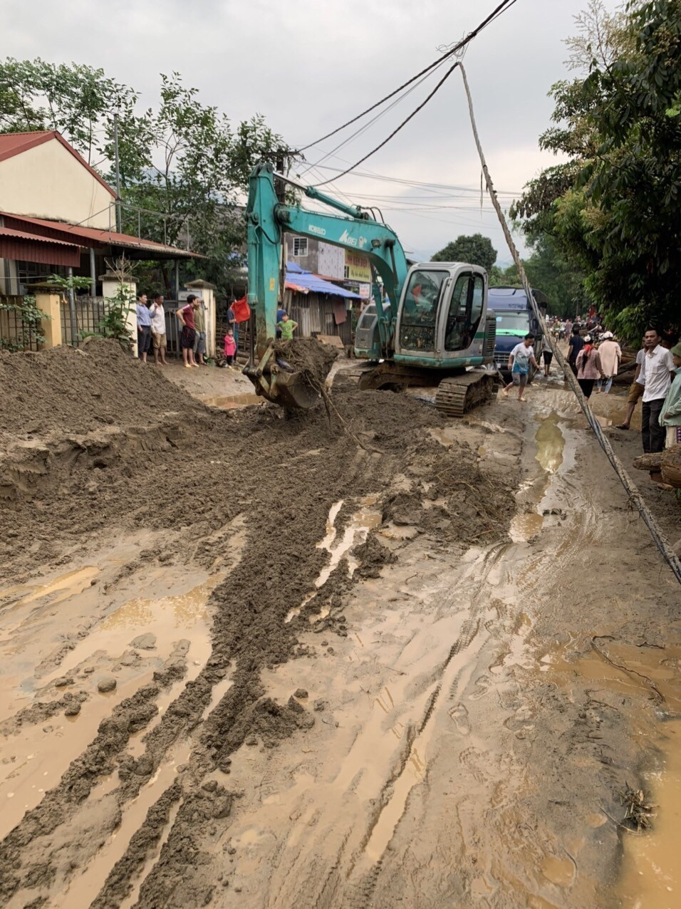 Lực lượng chức năng huy động phương tiện máy móc khắc phục hậu quả mưa lũ. (Ảnh TTXVN phát)
