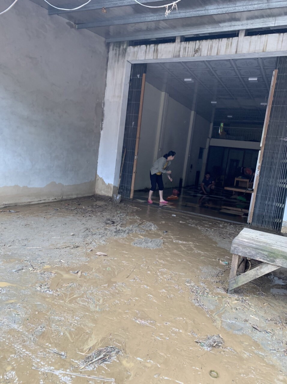 Người dân xã Minh Lương dọn bùn đất tràn vào nhà. (Ảnh TTXVN phát)