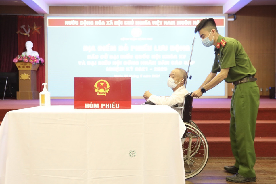 Cử tri là bệnh nhân được hỗ trợ đến điểm bỏ phiếu tại bệnh viện Bạch Mai. (Ảnh: Minh Quyết/TTXVN)