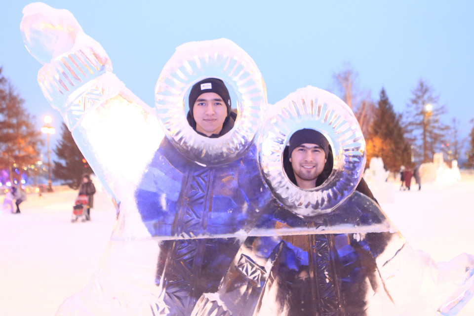 Du khách thích thú ghi lại những hình ảnh ấn tượng cùng với các tác phẩm điêu khắc băng. (Ảnh: Trần Hiếu/TTXVN)