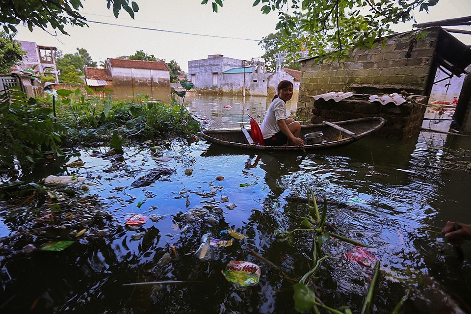 Tình trạng ngập lụt có thể sẽ kéo dài trong nhiều ngày tới và vấn đề về vệ sinh môi trường ở nơi đây đang thực sự là một hiểm họa đối với sức khỏe người dân khi ngày ngày họ vẫn phải đi lại và sinh hoạt trong biển nước mênh mông với vô vàn rác thải. (Ảnh: Trọng Đạt/TTXVN)