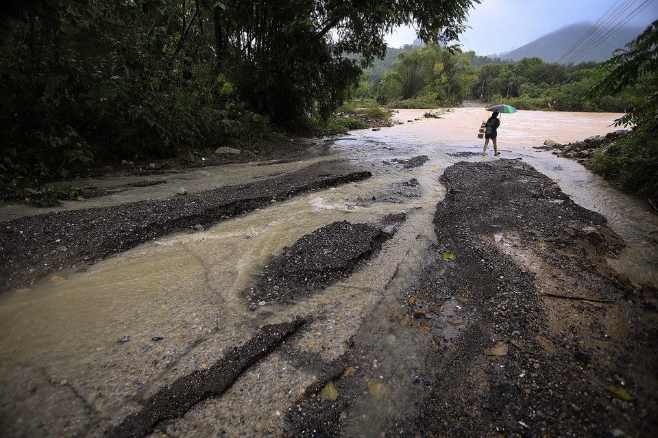 Nước lũ tràn ngầm trên một nhánh suối chảy ra sông Bùi và làm hư hại đường trên địa phận xã Tân Vinh. (Ảnh: Trọng Đạt/TTXVN)