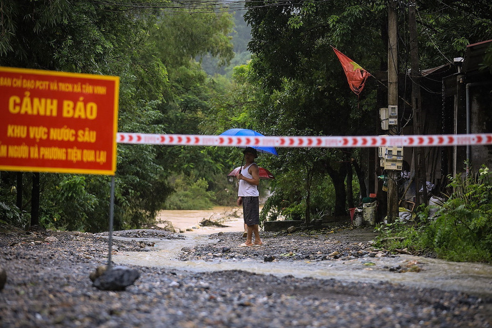 Biển cảnh báo được đặt tại điểm ngập lụt trên con đường liên xã từ xóm Nước vải đi Xóm Rụt, xã Tân Vinh. (Ảnh: Trọng Đạt/TTXVN)