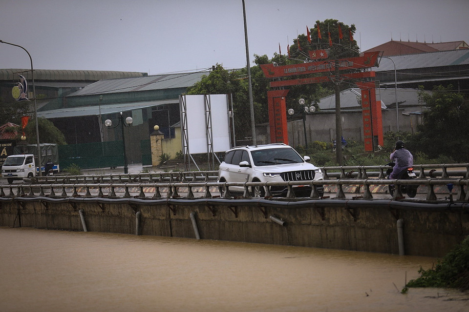 Người và phương tiện lưu thông qua cầu Bãi Sỏi, xã Nhuận Trạch ra Quốc lộ 6. (Ảnh: Trọng Đạt/TTXVN)