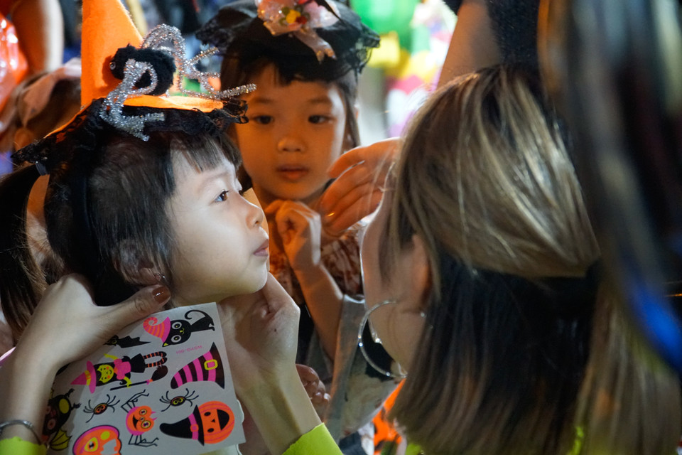 Các em bé thích thú với việc dán những sticker đủ hình thù lên mặt. (Ảnh: Minh Hiếu/Vietnam+)