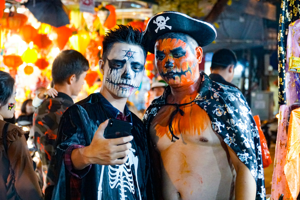 Anh Nguyễn Duy (bên trái, ở quận Đống Đa, Hà Nội) chia sẻ để ngồi trang điểm cho tạo hình của anh mất khoảng hơn 1 tiếng đồng hồ. Dù đã có gia đình nhưng anh vẫn có sở thích vẽ hình để tạo niềm vui với bạn bè và bản thân. (Ảnh: Minh Hiếu/Vietnam+)