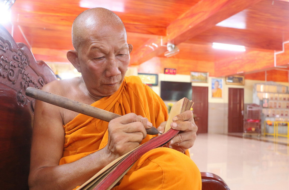 Hòa thượng Chau Sơn Hy, Sư cả chùa Sà Lôn ở xã Lương Phi, huyện Tri Tôn (An Giang), trình diễn kỹ thuật viết kinh bằng chữ Pali trên lá buông. (Ảnh: Công Mạo/TTXVN)
