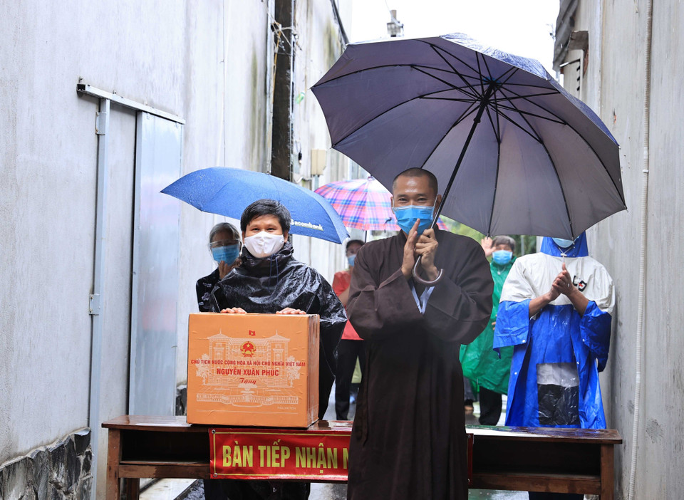 Nhân dân trong khu vực phong toả tại thị trấn Hóc Môn được nhận quà của Chủ tịch nước Nguyễn Xuân Phúc. (Ảnh: Thống Nhất/TTXVN)