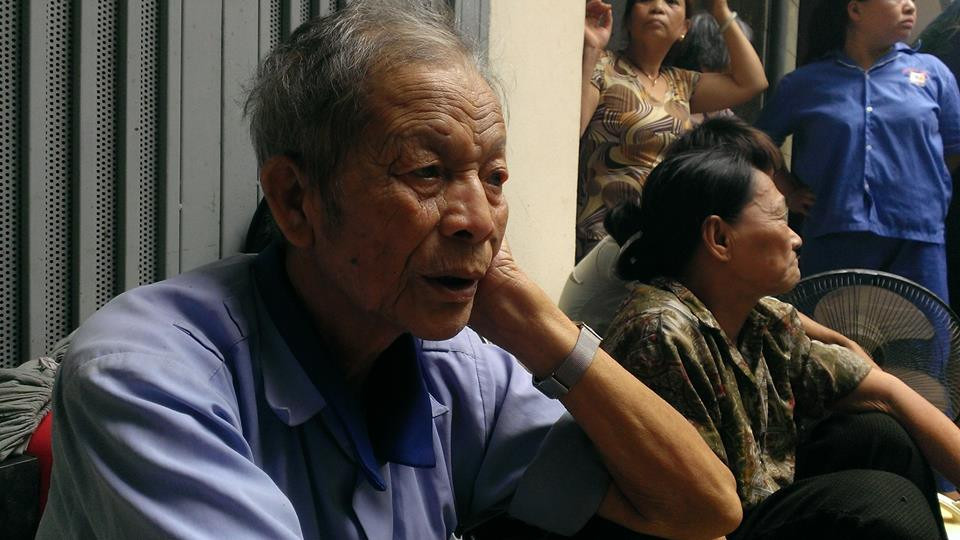 Ông Phạm Ngọc Sơn và bà Đào Thị Thêm được cán bộ trật tự phường Văn Chương cõng ra khỏi đám cháy. (Ảnh: Võ Phương/Vietnam+)