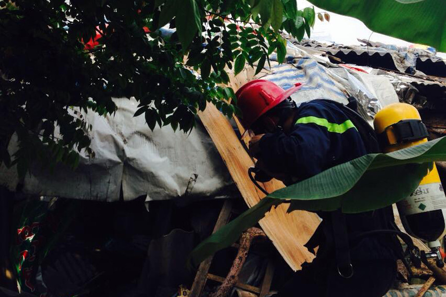 Hiện lực lượng cứu hoả đã phải tăng cường bình khí chống độc để vào sâu hơn trong hiện trường. (Ảnh: Sơn Bách/Vietnam+)