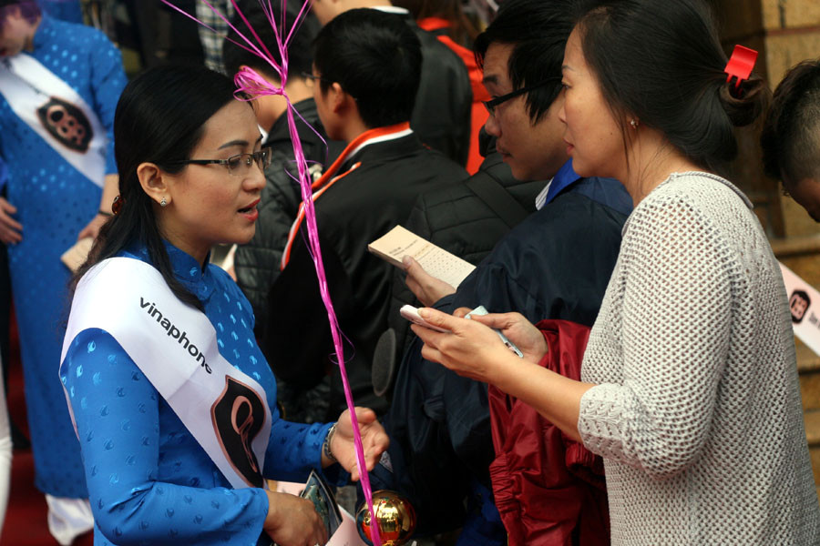 Nhân viên VinaPhone Hà Nội hướng dẫn người xếp hàng. (Ảnh: T.H/Vietnam+)