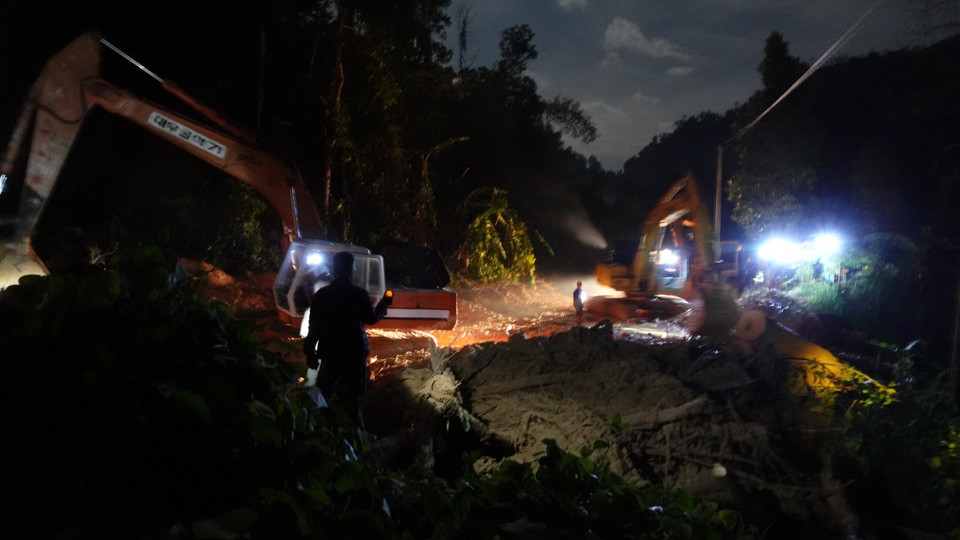 Lực lượng chức năng khẩn trương thông đường vào khu vực sạt lở Trà Leng. (Ảnh: Vỹ Thi/TTXVN)