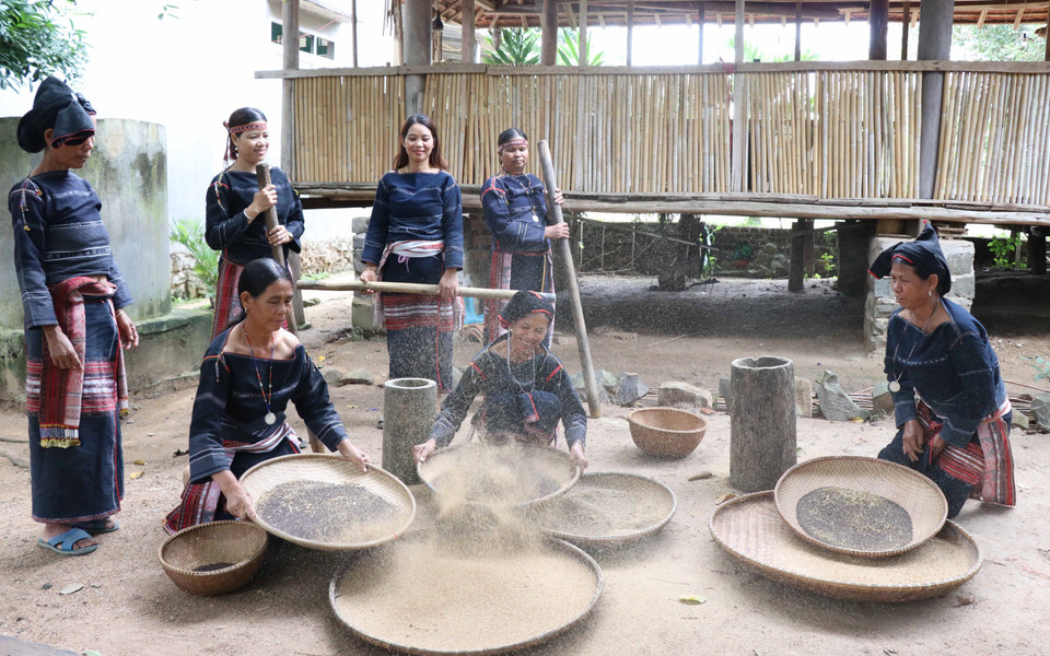 Phụ nữ trong làng tập trung giã, sàng sẩy để lựa chọn hạt Cào đạt chuẩn nấu rượu cần. (Ảnh: Hồng Điệp/TTXVN)