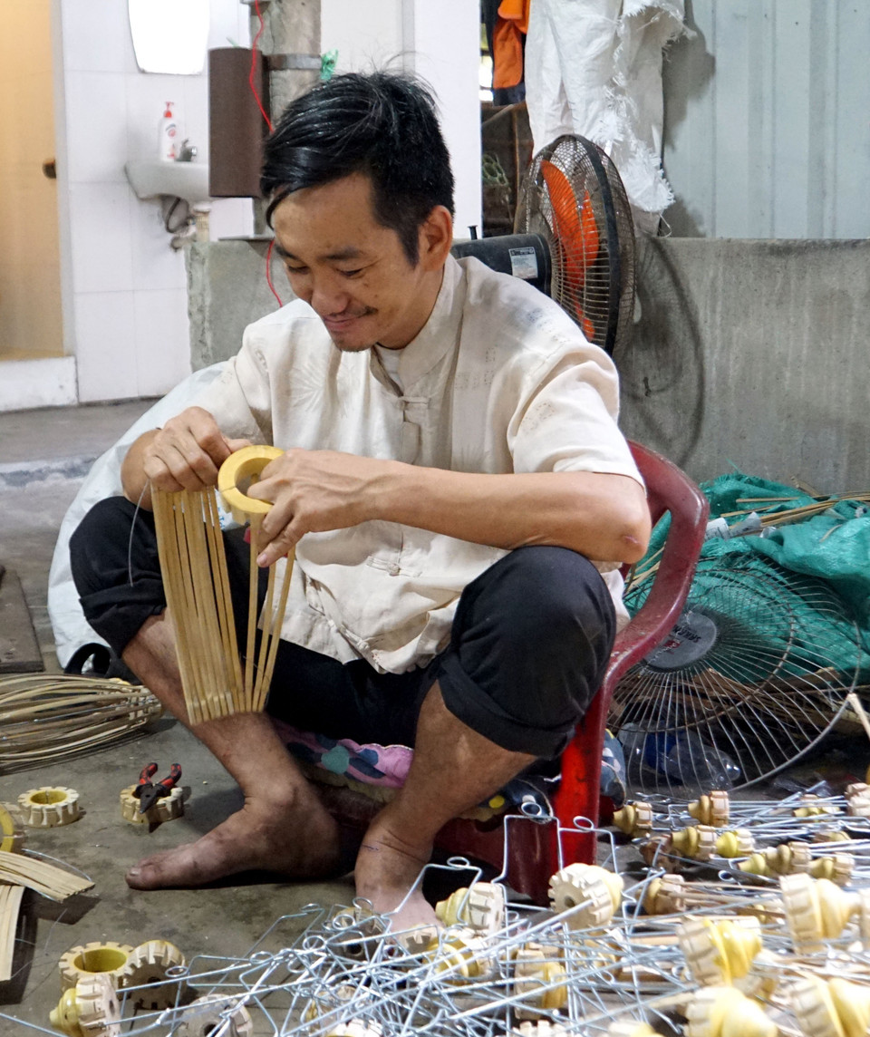 Các nghệ nhân thực hiện các công đoạn trong sản xuất đèn lồng ở thành phố Hội An. (Ảnh: Trịnh Bang Nhiệm/TTXVN)