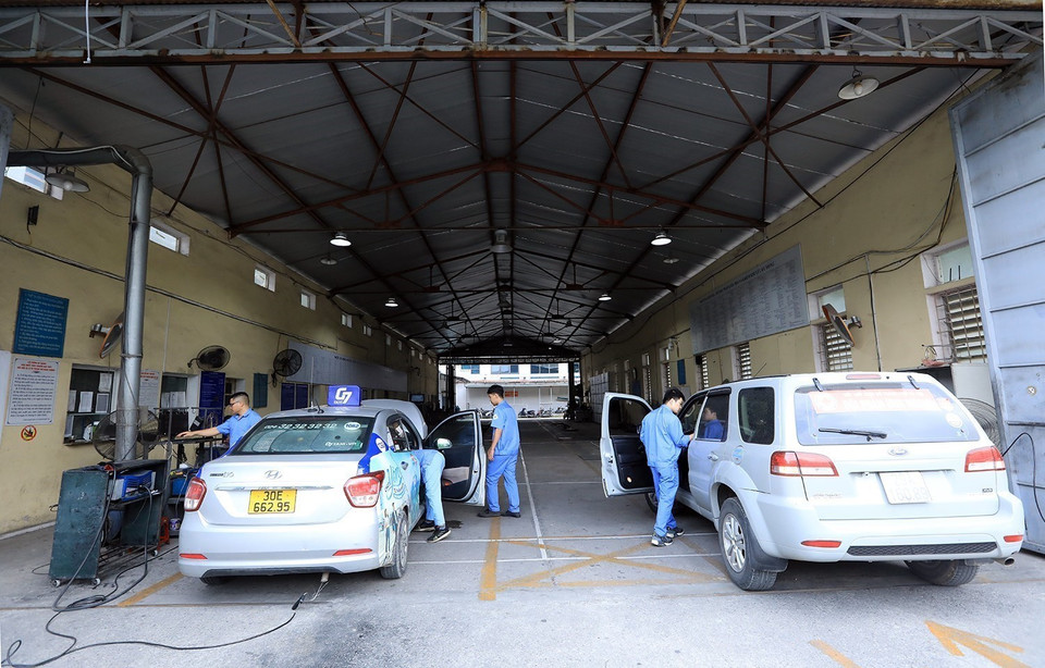 Các Đăng kiểm viên Trung tâm đăng kiểm 29-03V kiểm tra thông số kỹ thuật phương tiện đến đăng kiểm. (Ảnh: Tuấn Anh/TTXVN)