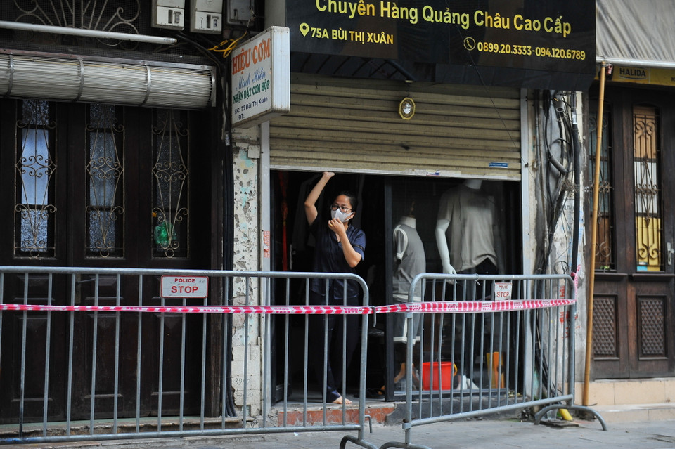 Lực lượng chức năng lập chốt chặn, phong tỏa và tăng cường tuần tra kiểm soát nhắc nhở người dân tại khu vực số nhà 89 Bùi Thị Xuân. (Ảnh: Minh Đức/TTXVN)