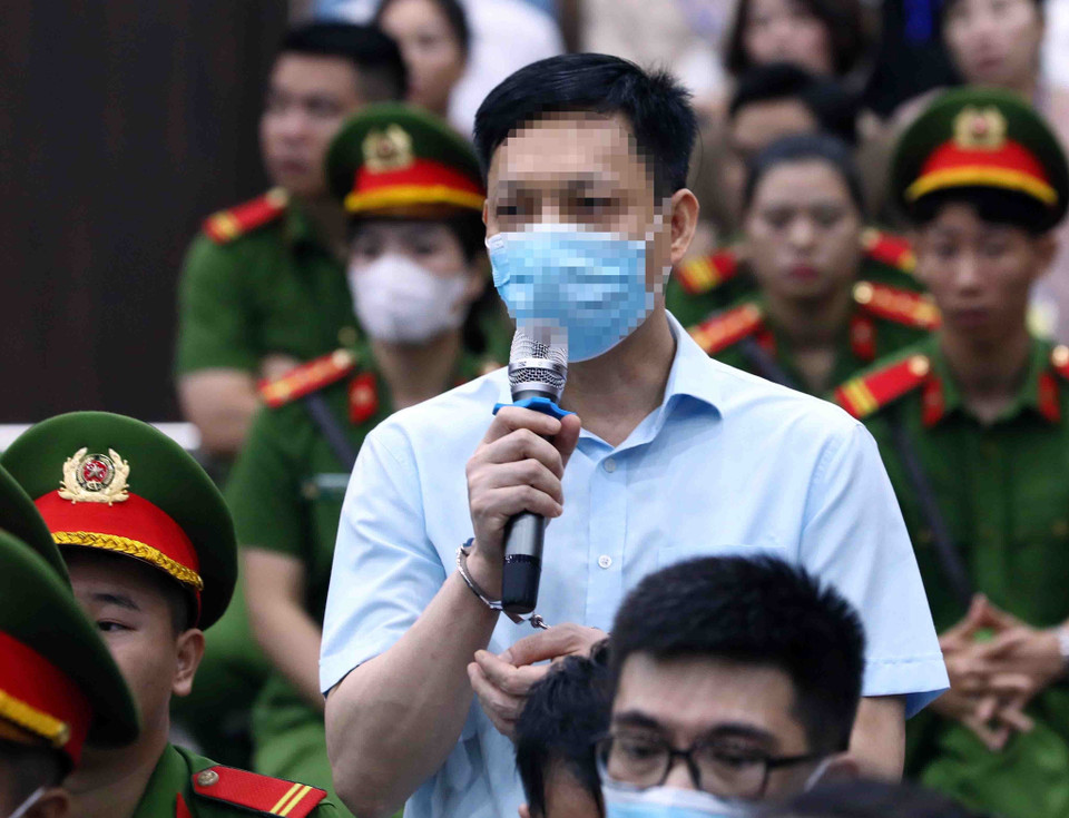 Bị cáo Vũ Anh Tuấn, cựu cán bộ Cục Quản lý Xuất Nhập cảnh, Bộ Công an, khai báo trước tòa. (Ảnh: Phạm Kiên/TTXVN)