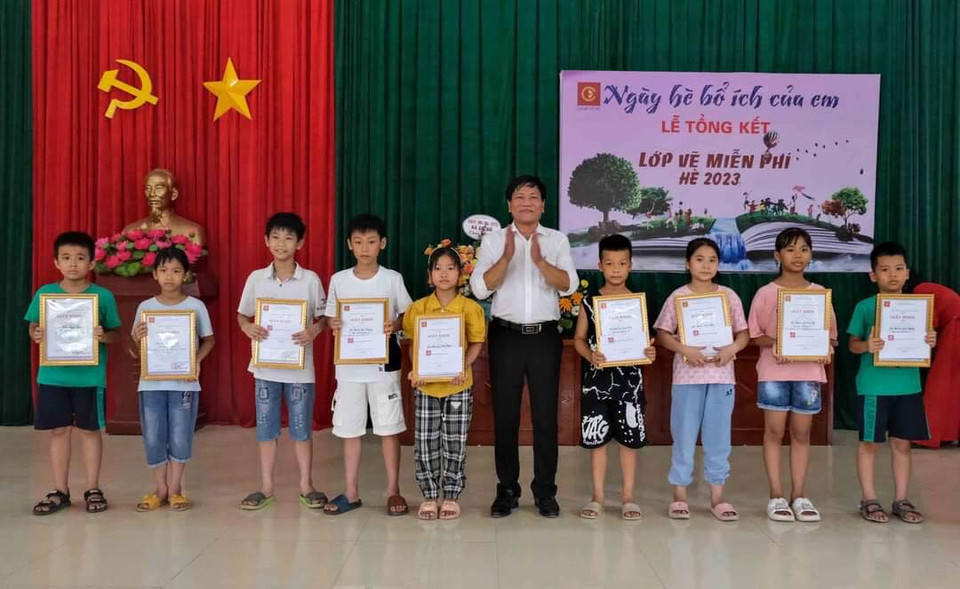 Họa sỹ Hoàng Tuấn Việt, Chủ nhiệm Câu lạc bộ Mỹ thuật Cổ Đô trao giấy khen cho những học sinh hoàn thành xuất sắc khóa học. (Nguồn: Vietnam+)