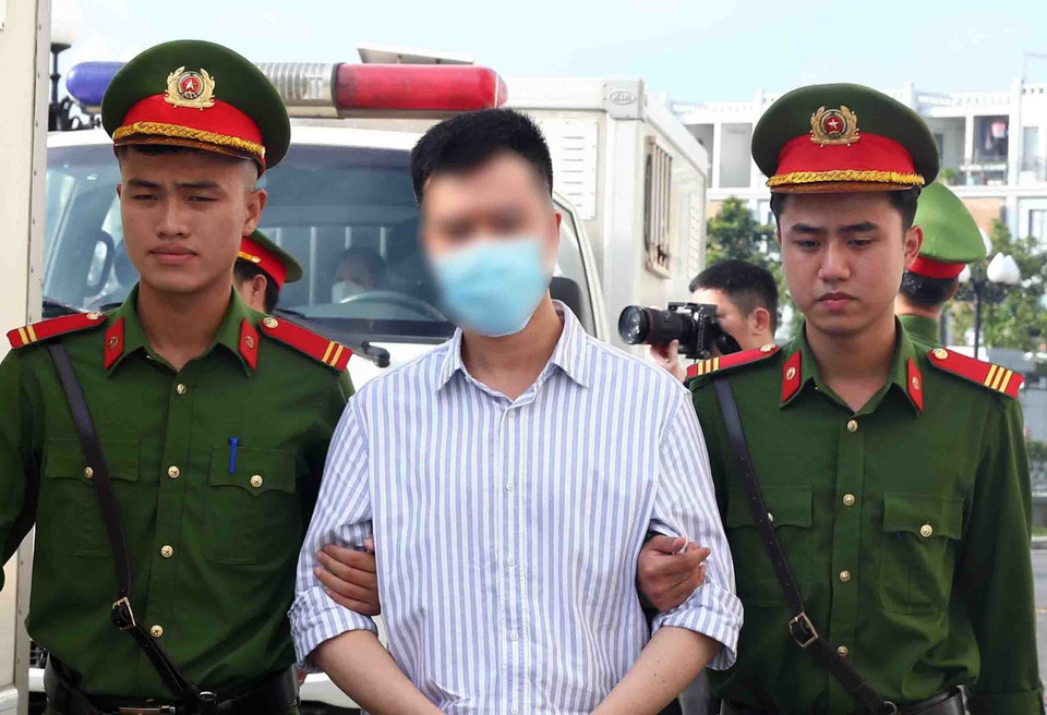 Lực lượng chức năng dẫn giải các bị cáo tới phiên tòa xét xử. (Ảnh: Phạm Kiên/TTXVN)