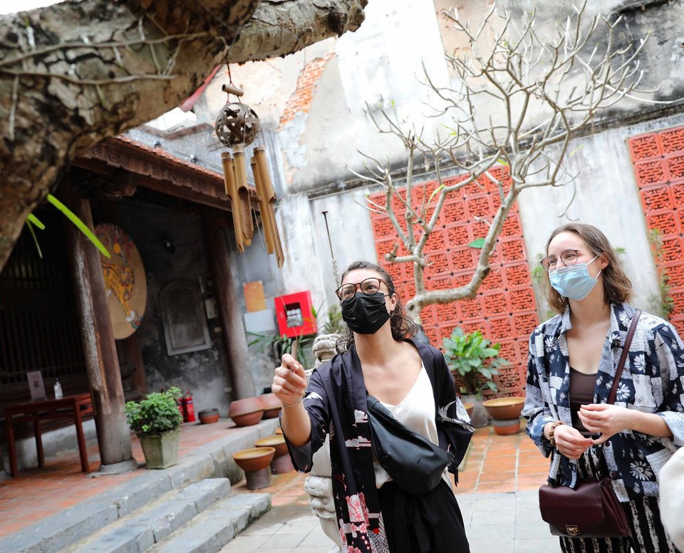 Du khách quốc tế tìm hiểu văn hóa Việt Nam khi tham quan đình Kim Ngân, quận Hoàn Kiếm. (Ảnh: Thanh Tùng/TTXVN)