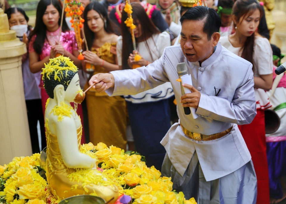 Nghi thức tắm tượng phật bằng nước ướp hương, gột rửa những điều không may mắn năm cũ để sang năm mới mọi sự được như ý. (Ảnh: Tuấn Đức/TTXVN) 