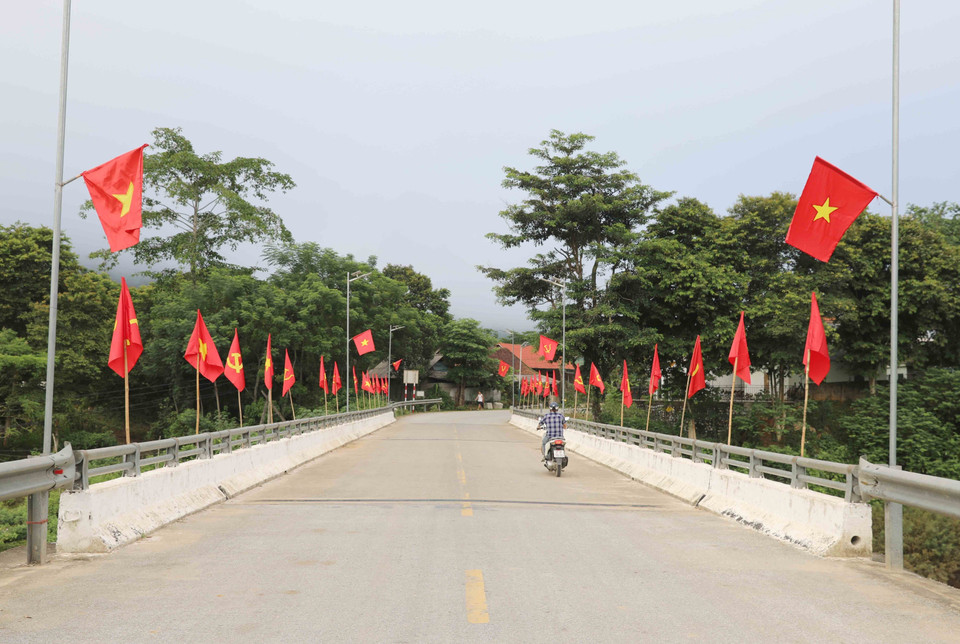 Cờ Tổ quốc được cắm trên cầu Bản Pột (quốc lộ 48C), là cửa ngõ vào trung tâm xã miền núi, vùng cao Nga My (huyện Tương Dương, Nghệ An). (Ảnh: Xuân Tiến/TTXVN)