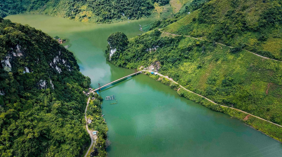 Nhìn từ trên cao, cầu treo Pa Phông hiện lên trên nền nước xanh biếc, giữa hai bên là núi non hùng vĩ. (Ảnh: Xuân Tư/ TTXVN)