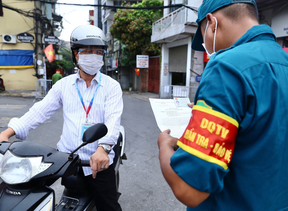 Lực lượng chức năng kiểm tra giấy tờ người dân khu vực không bị khoanh vùng, được phép ra ngoài (ảnh chụp tại cửa khẩu Cầu Đất sáng 17/8). (Ảnh: Hoàng Hiếu/TTXVN)