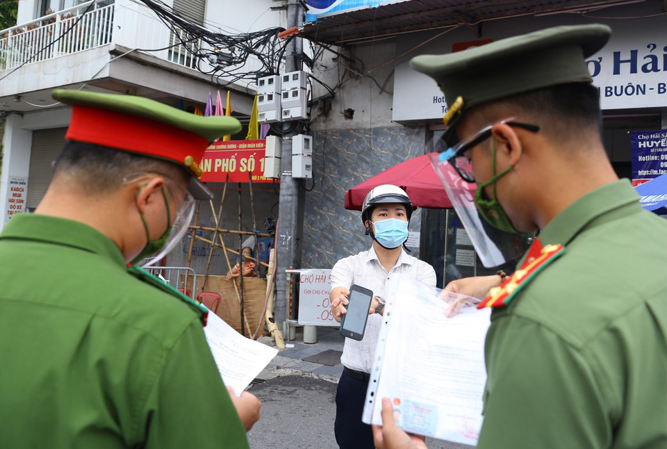 Người dân phường Chương Dương khu vực không bị khoanh vùng khai báo với lực lượng chức năng khi được phép ra ngoài. (Ảnh: Hoàng Hiếu/TTXVN)