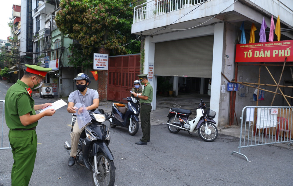 Công an kiểm tra giấy tờ đi đường của người dân phường Chương Dương khu vực được phép ra ngoài khi cần thiết (ảnh chụp sáng 17/8 tại cửa khẩu Cầu Đất). (Ảnh: Hoàng Hiếu/TTXVN)