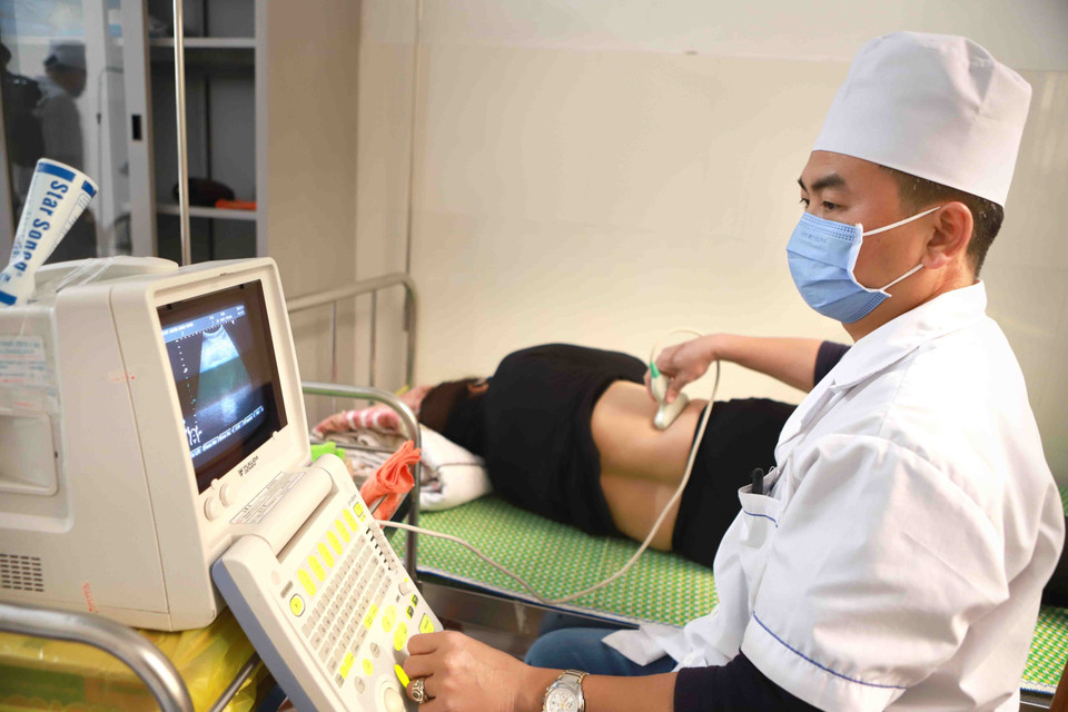 Siêu âm cho người dân đến khám tại Trạm y tế xã Sơn Lôi. (Ảnh: Hoàng Hùng/TTXVN)