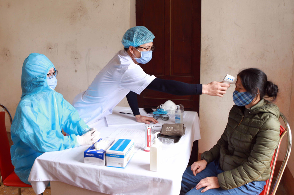 Kiểm tra nhiệt độ cho người dân tại khu cách ly của Trạm y tế xã Sơn Lôi. (Ảnh: Hoàng Hùng/TTXVN)