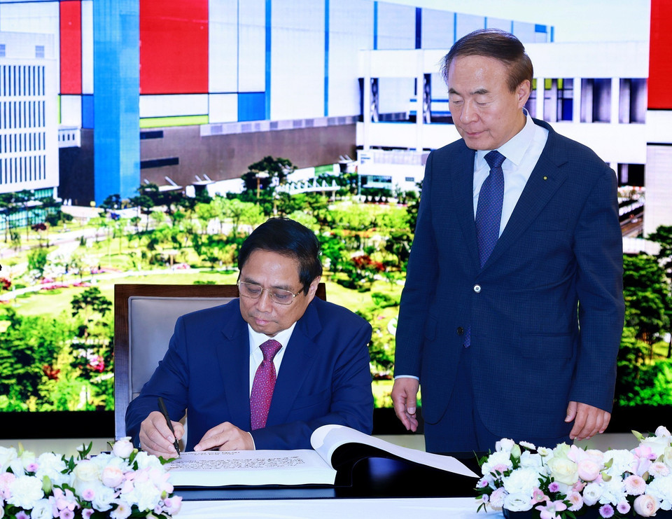 Thủ tướng Phạm Minh Chính viết lưu bút khi đến thăm Tổ hợp bán dẫn Samsung tại tỉnh Gyeonggi, Hàn Quốc. (Ảnh: Dương Giang/TTXVN)