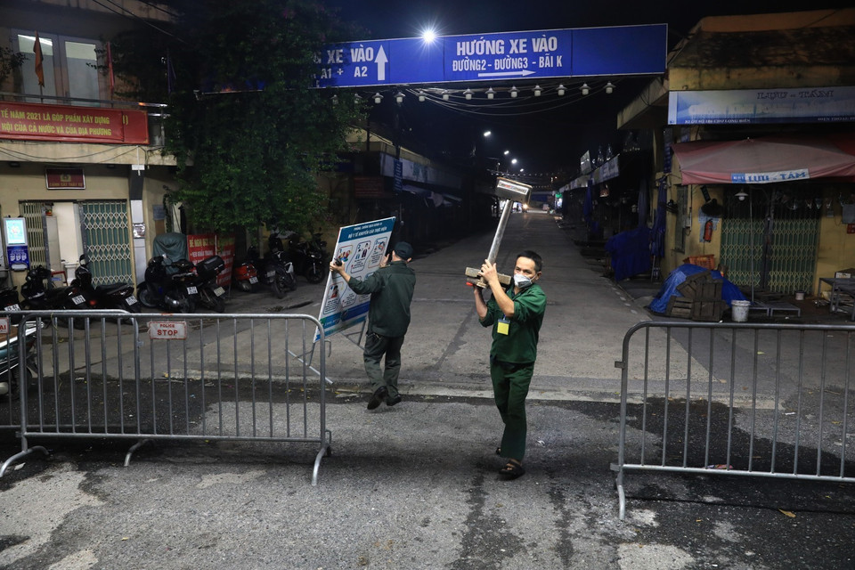 Đúng 0h ngày 21/10/2021, lực lượng chức năng gỡ rào phong tỏa, chợ Long Biên chính thức mở cửa hoạt động trở lại. (Ảnh: Thành Đạt/TTXVN)