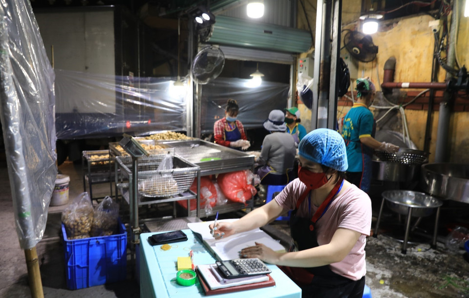 0h ngày 21/10, chợ Long Biên được mở cửa các tiểu thương hối hả chuẩn bị bốc hàng, chuẩn bị hàng hóa cho ngày giao dịch đầu tiên. (Ảnh: Thành Đạt/TTXVN)