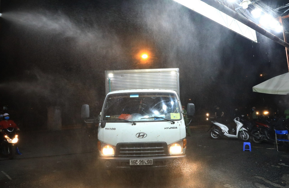 Phun khử khuẩn các phương tiện ra vào chợ Long Biên. (Ảnh: Thành Đạt/TTXVN)