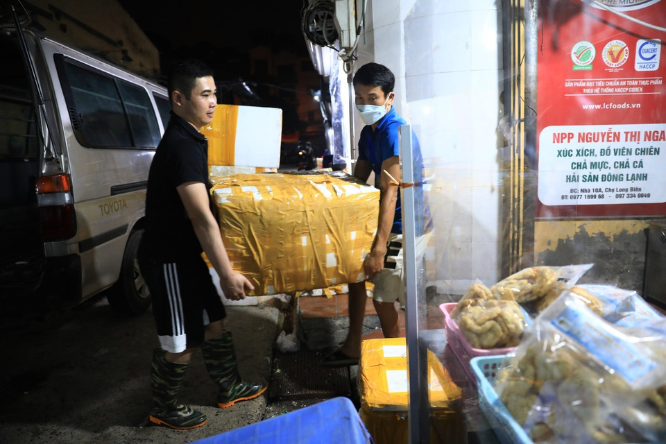 0h ngày 21/10, chợ Long Biên được mở cửa các tiểu thương hối hả chuẩn bị bốc hàng, chuẩn bị hàng hóa cho ngày giao dịch đầu tiên. (Ảnh: Thành Đạt/TTXVN)