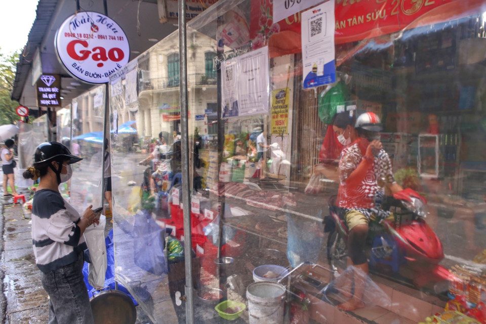 Chợ dân sinh trên phố Nguyễn Văn Tố (Hoàn Kiếm) có vách ngăn đảm bảo khoảng cách giữa người bán và người mua.(Ảnh: Tuấn Đức/TTXVN)