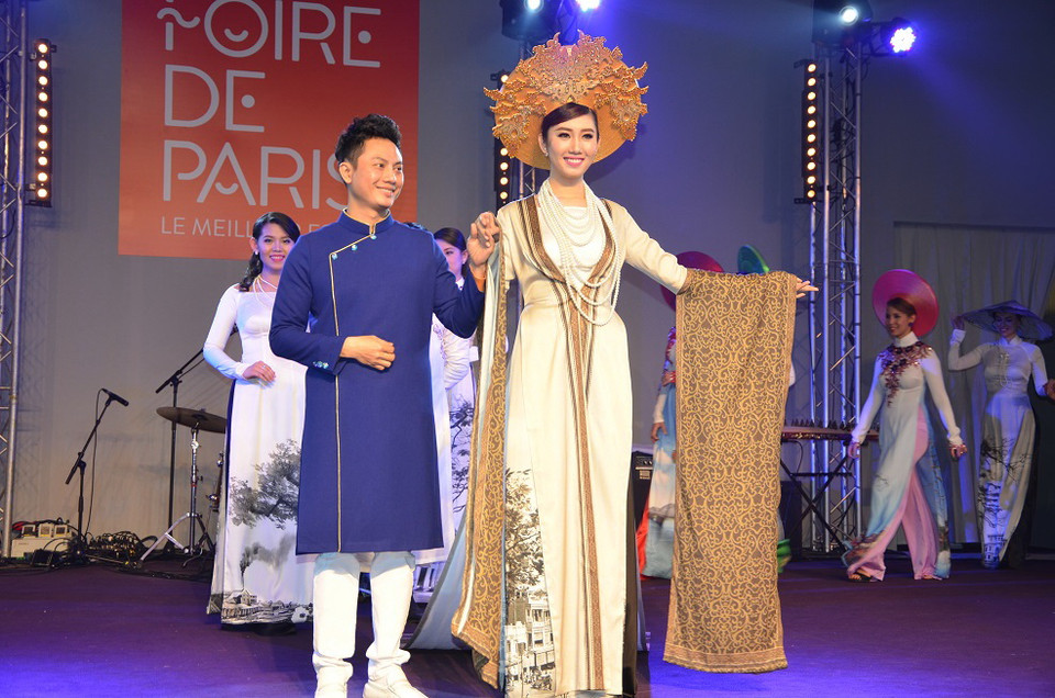 Nhà thiết kế Ngô Nhật Huy tham gia giới thiệu áo dài cùng người mẫu. (Ảnh: Bích Hà/Vietnam+)