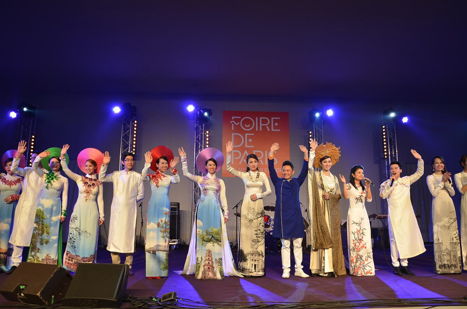 Nhà thiết kế Ngô Nhật Huy (áo xanh) cùng dàn người mẫu chào khán giả sau phần trình diễn. (Ảnh: Bích Hà/Vietnam+)