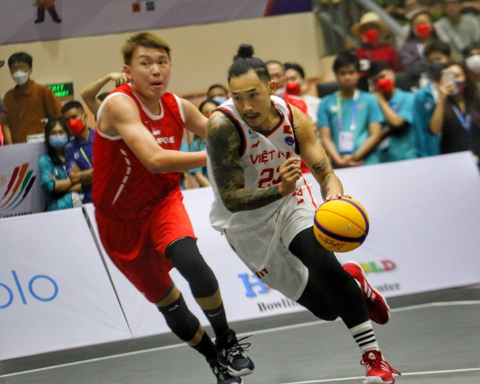 Đinh Thanh Tâm (số 23, Việt Nam) dẫn bóng trước sự kìm kẹp của Larry Liew (số 11, Singapore). (Ảnh: Tuấn Đức/TTXVN)