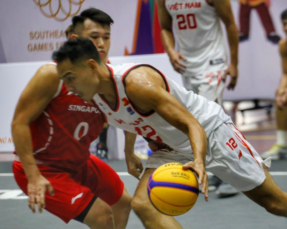 Pha dẫn bóng của Justin Young (số 12, nam Việt Nam) trong sự truy cản của Lim Yuan (số 0, nam Singapore). (Ảnh: Tuấn Đức/TTXVN)