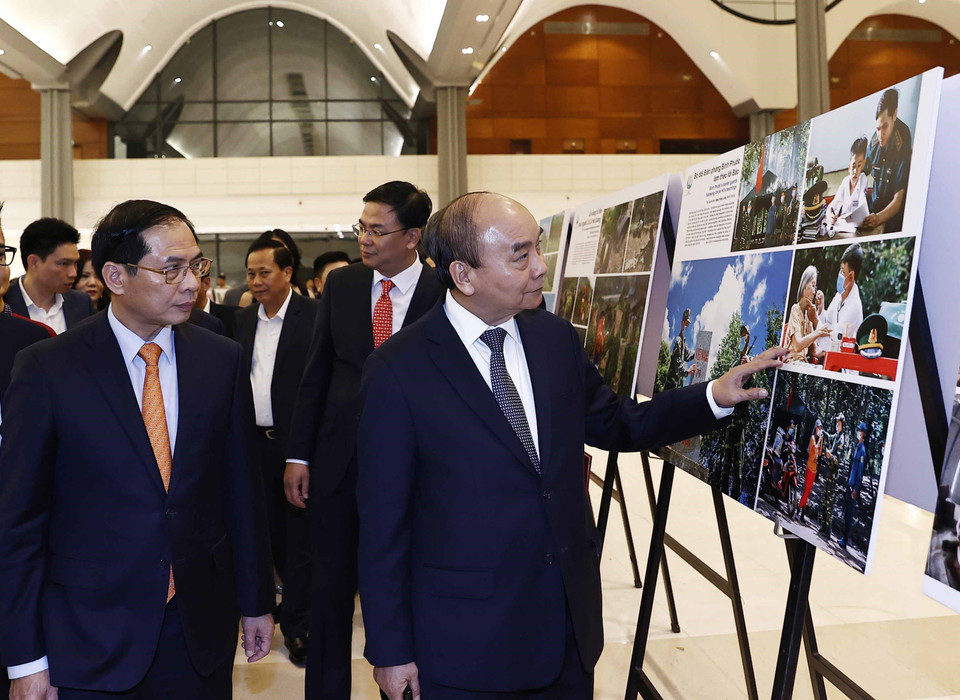 Chủ tịch nước Nguyễn Xuân Phúc xem trưng bày ảnh tại Chương trình Xuân Quê hương năm 2023. (Ảnh: Thống Nhất/TTXVN)