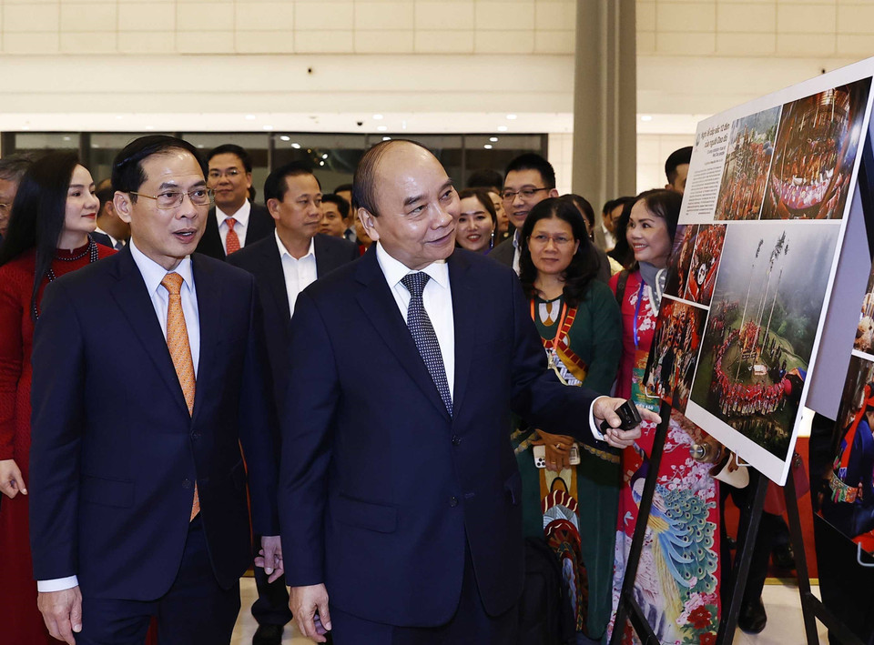 Chủ tịch nước Nguyễn Xuân Phúc xem trưng bày ảnh tại Chương trình Xuân Quê hương năm 2023. (Ảnh: Thống Nhất/TTXVN)