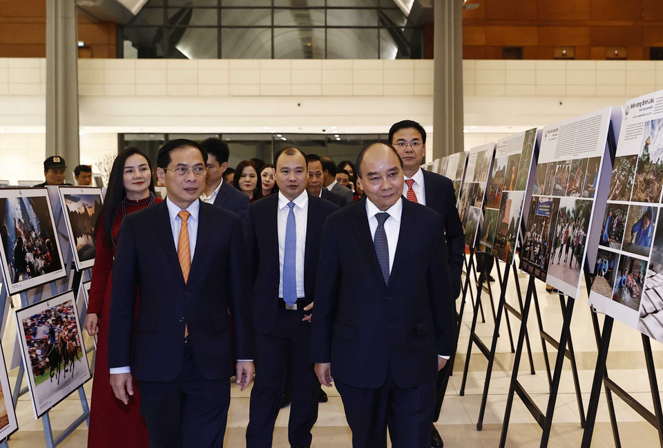 Chủ tịch nước Nguyễn Xuân Phúc xem trưng bày ảnh tại Chương trình Xuân Quê hương năm 2023. (Ảnh: Thống Nhất/TTXVN)